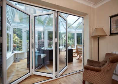 white bifold doors leading in to a upvc conservatory Matson4186